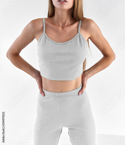 fit girl wears leggings and sleeveless top isolated white background. woman standing and posing in sport outfit for summer