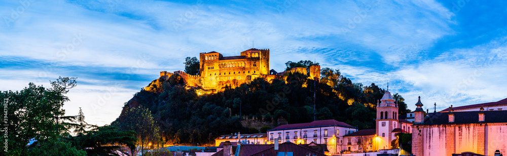 Skyline of the castle of Leiria on a hill top surrounded by trees and buildings in the old town of Leiria, Portugal