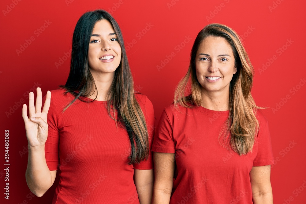 Hispanic family of mother and daughter wearing casual clothes over red background showing and pointing up with fingers number four while smiling confident and happy. Hispanic family of mother and daughter wearing casual clothes over red background showing and pointing up with fingers number four while smiling confident and happy.