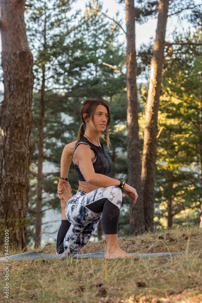 Woman practices yoga alone in the forest Back view Outdoor activity Young attractive Asian woman practicing yoga, exercising exercising working out Women is meditating alone at sunrise. Woman practices yoga alone in the forest Back view Outdoor activity Young attractive Asian woman practicing yoga, exercising exercising working out Women is meditating alone at sunrise.