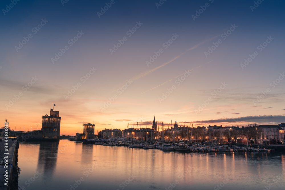Panoramic view of the old harbor of La Rochelle at sunset with its famous old towers