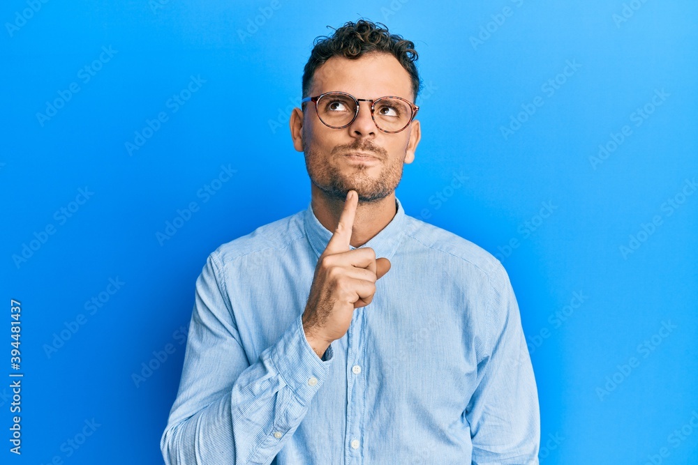 Handsome man with beard wearing casual clothes and glasses smiling positive doing ok sign with hand and fingers. successful expression. Handsome man with beard wearing casual clothes and glasses smiling positive doing ok sign with hand and fingers. successful expression.