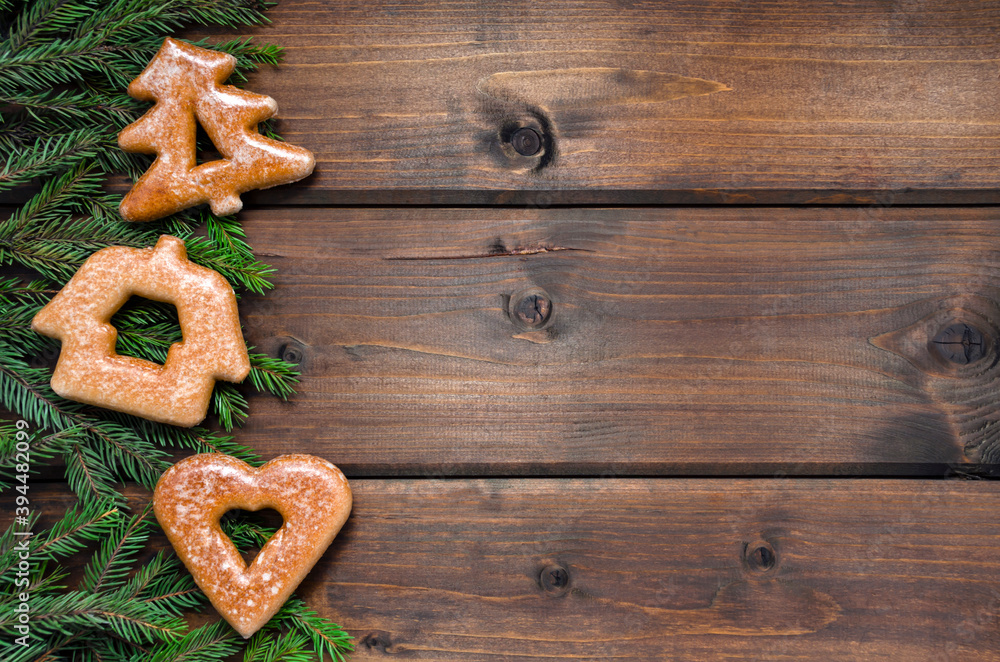 Gingerbread cookies and fir branches on a dark wooden background. Christmas blank for text, congratulations, inscriptions. with place for text. new Year Gingerbread cookies and fir branches on a dark wooden background. Christmas blank for text, congratulations, inscriptions. with place for text. new Year