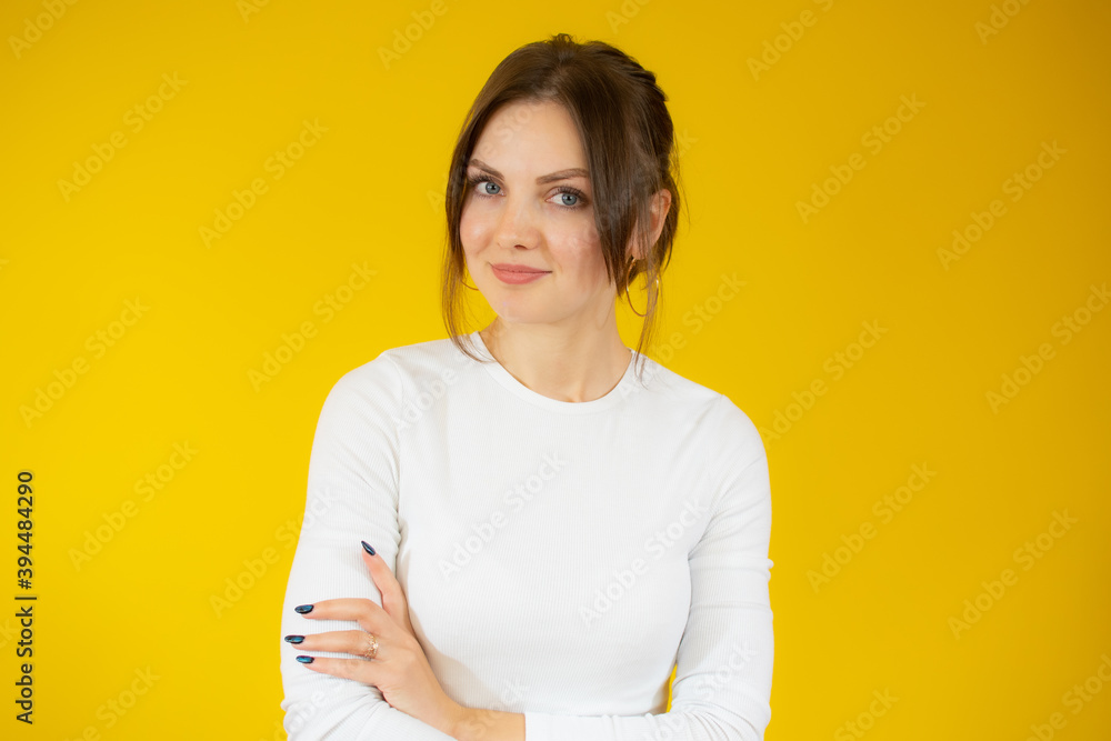 Smiling young brunette woman in white sweater posing isolated on yellow background studio portrait. People sincere emotions lifestyle concept. Mock up copy space. Holding hands crossed Smiling young brunette woman in white sweater posing isolated on yellow background studio portrait. People sincere emotions lifestyle concept. Mock up copy space. Holding hands crossed