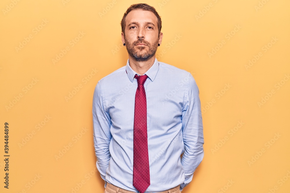 Young handsome man wearing business clothes with serious expression on face. simple and natural looking at the camera. Young handsome man wearing business clothes with serious expression on face. simple and natural looking at the camera.