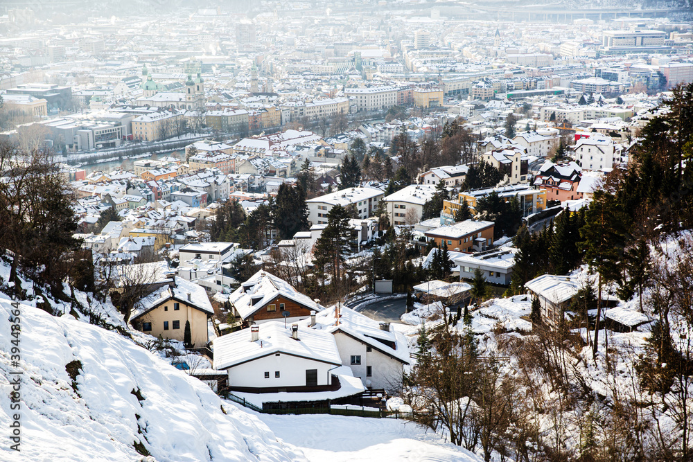 Innstruck in winter, Austria. Beautiful aerial view, house roofes covered with snow, Alps mountains on the background.