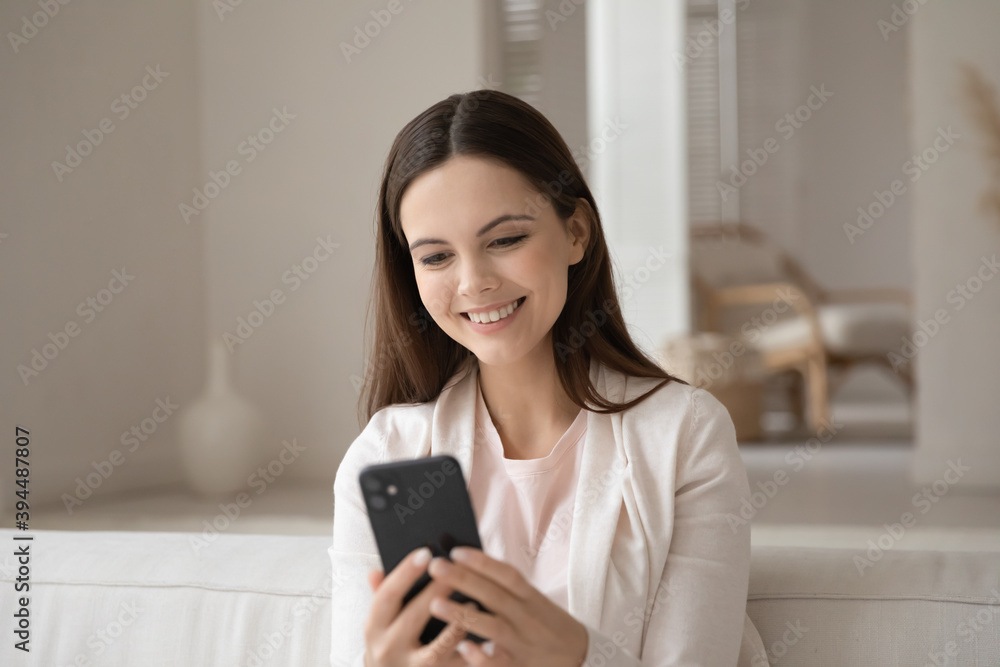 Pleasant talk. Smiling positive young lady student teenager sitting on soft couch at home enjoying video conversation by smartphone, chatting flirting using cellphone webcam, shopping at online store Pleasant talk. Smiling positive young lady student teenager sitting on soft couch at home enjoying video conversation by smartphone, chatting flirting using cellphone webcam, shopping at online store