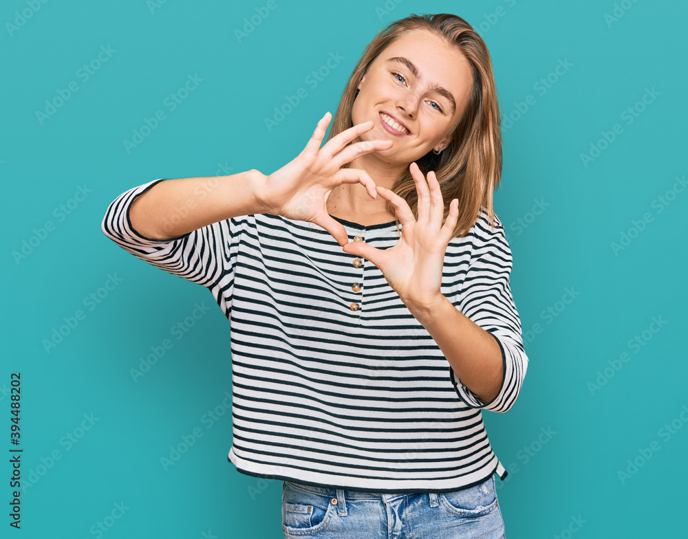 Beautiful blonde woman wearing casual clothes smiling in love doing heart symbol shape with hands. romantic concept. Beautiful blonde woman wearing casual clothes smiling in love doing heart symbol shape with hands. romantic concept.