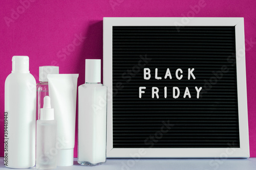 Beauty spa treatment skincare cosmetic cream facial mockup tube container product packaging on purple background, Black Friday on letter board. Cosmetic discount concept