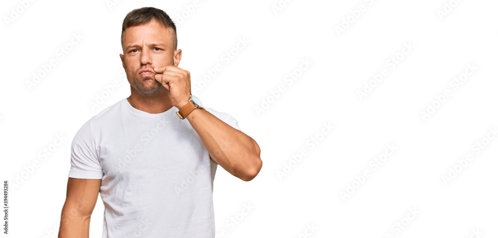 Handsome muscle man wearing casual white tshirt mouth and lips shut as zip with fingers. secret and silent, taboo talking Handsome muscle man wearing casual white tshirt mouth and lips shut as zip with fingers. secret and silent, taboo talking