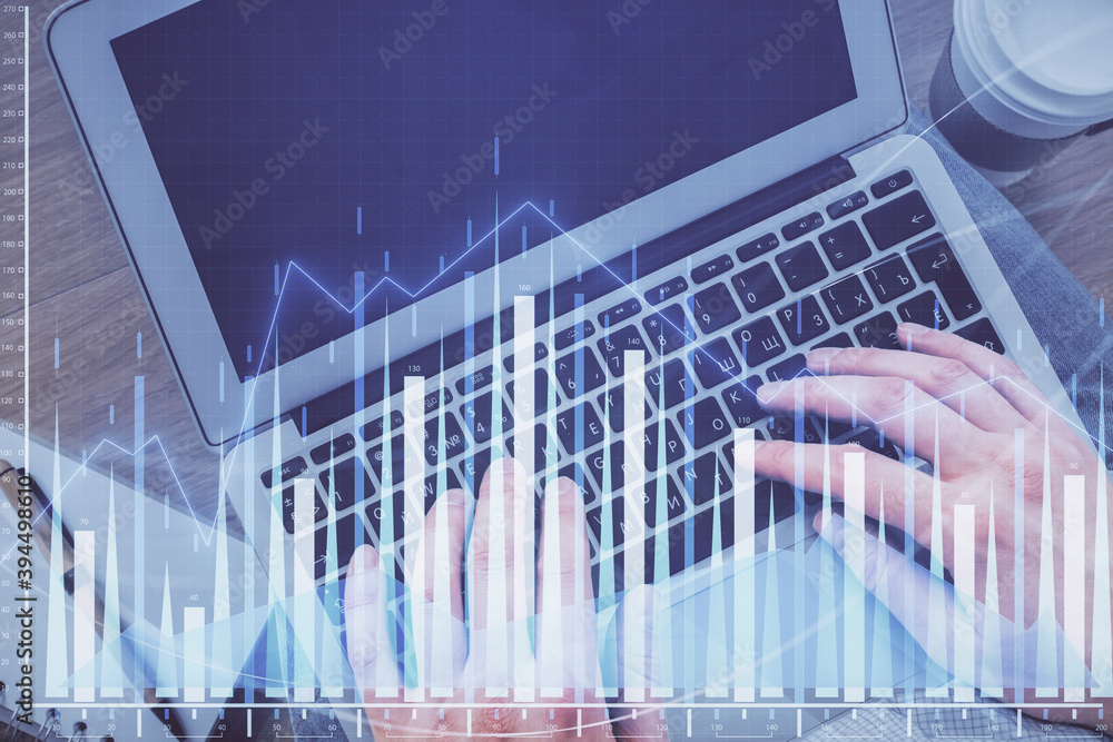Double exposure of man's hands typing over computer keyboard and forex graph hologram drawing. Top view. Financial markets concept. Double exposure of man's hands typing over computer keyboard and forex graph hologram drawing. Top view. Financial markets concept.