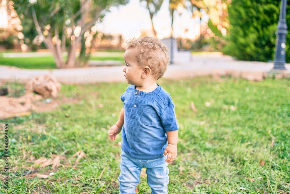 Cute and happy little boy having fun at the park on a sunny day. Beautiful blonde hair male toddler playing outdoors Cute and happy little boy having fun at the park on a sunny day. Beautiful blonde hair male toddler playing outdoors