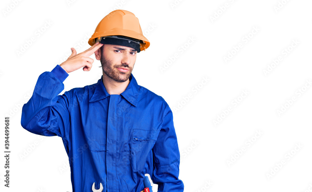 Young hispanic man wearing worker uniform shooting and killing oneself pointing hand and fingers to head like gun, suicide gesture. Young hispanic man wearing worker uniform shooting and killing oneself pointing hand and fingers to head like gun, suicide gesture.