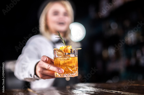 Girl bartender mixes a cocktail at the saloon photo