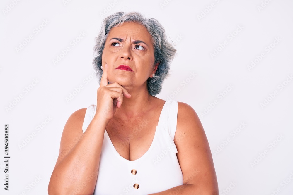 Senior hispanic woman wearing casual clothes serious face thinking about question with hand on chin, thoughtful about confusing idea