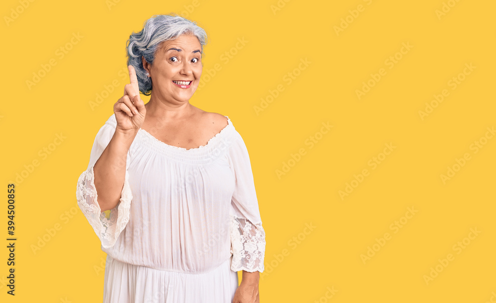 Senior woman with gray hair wearing bohemian style pointing finger up with successful idea. exited and happy. number one. Senior woman with gray hair wearing bohemian style pointing finger up with successful idea. exited and happy. number one.