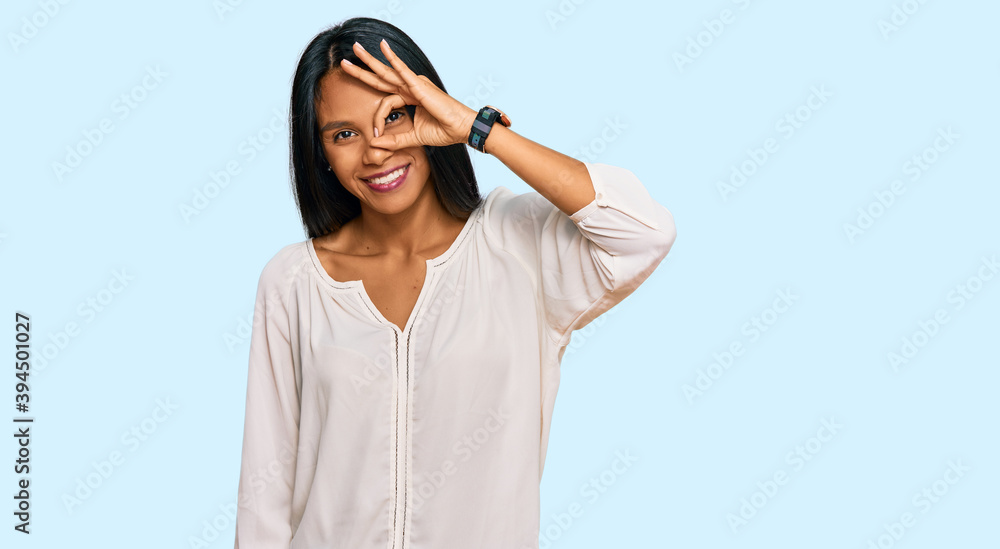 Young african american woman wearing casual clothes smiling happy doing ok sign with hand on eye looking through fingers Young african american woman wearing casual clothes smiling happy doing ok sign with hand on eye looking through fingers