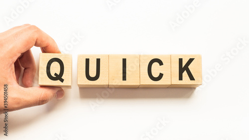Word quick. Wooden small cubes with letters isolated on white background with copy space available.Business Concept image.