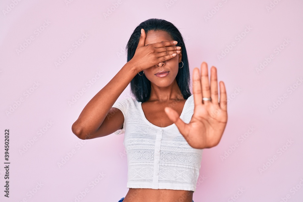 Young african american woman wearing casual clothes covering eyes with hands and doing stop gesture with sad and fear expression. embarrassed and negative concept. Young african american woman wearing casual clothes covering eyes with hands and doing stop gesture with sad and fear expression. embarrassed and negative concept.