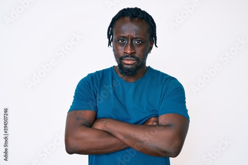 Young african american man with braids wearing casual clothes skeptic and nervous, disapproving expression on face with crossed arms. negative person.
