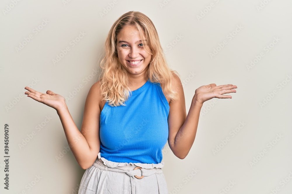 Young blonde girl wearing casual clothes celebrating victory with happy smile and winner expression with raised hands Young blonde girl wearing casual clothes celebrating victory with happy smile and winner expression with raised hands