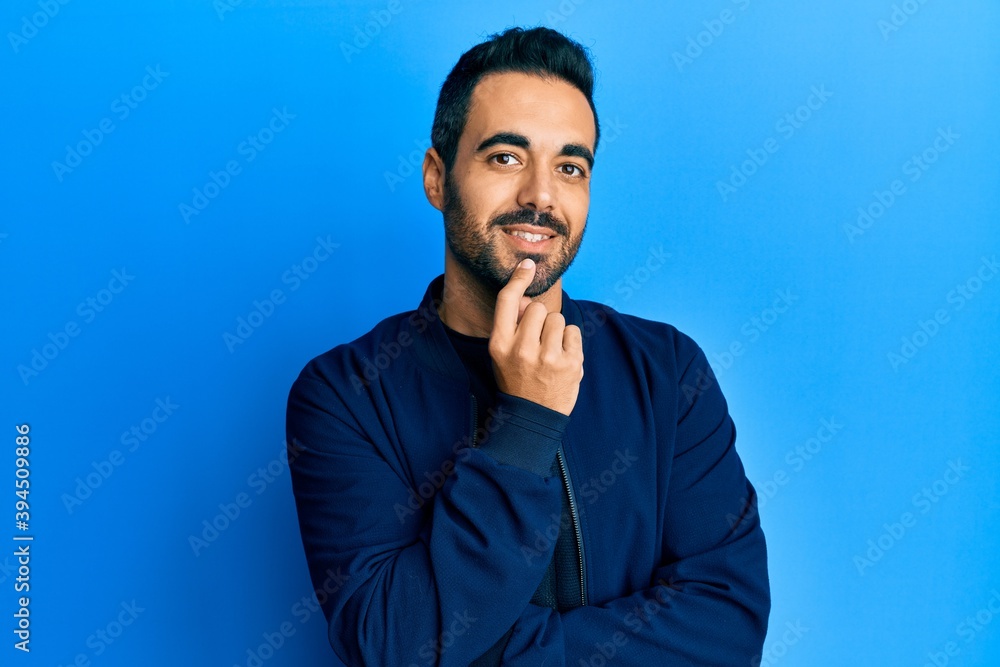 Young hispanic man with beard wearing casual clothes happy face smiling with crossed arms looking at the camera. positive person.