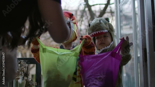 Trick or Treat! Cute kids dressed up in costumes collect candy from the neighbourhood. Shot in 4k. 