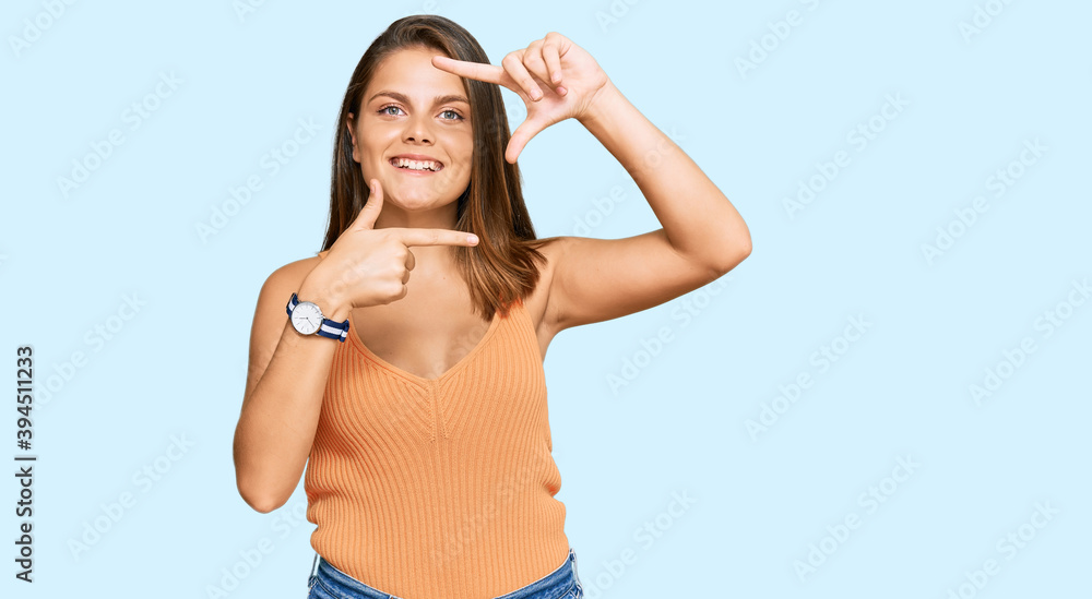 Fototapeta premium Young caucasian woman wearing casual clothes smiling making frame with hands and fingers with happy face. creativity and photography concept.