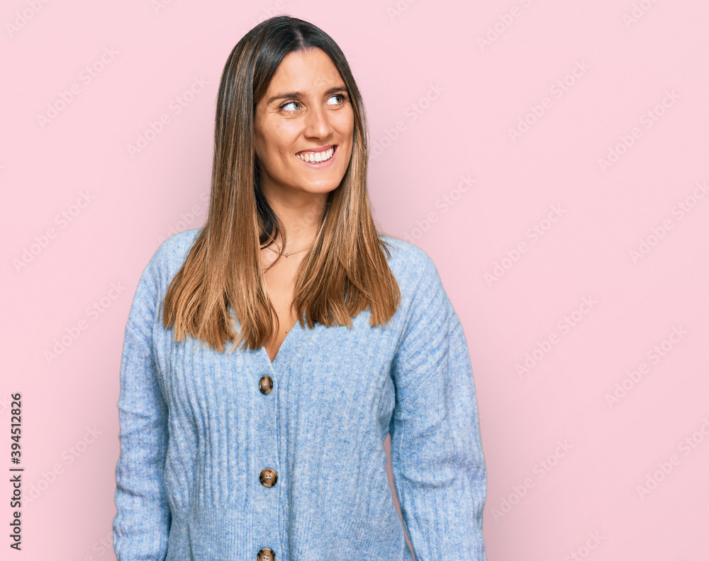 Fototapeta premium Young woman wearing casual clothes looking away to side with smile on face, natural expression. laughing confident.