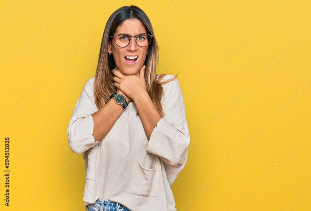 Young woman wearing casual clothes and glasses shouting and suffocate because painful strangle. health problem. asphyxiate and suicide concept.