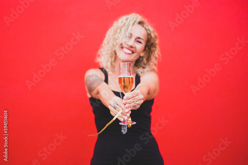 portrait beautiful curly woman celebrating new year 2021 smiling and looking at the camera holding a glass or cup with champagne