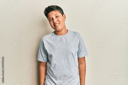 Hispanic teenager boy wearing casual clothes showing and pointing up with fingers number ten while smiling confident and happy. photo