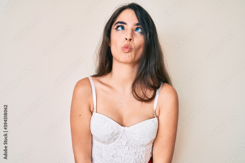 Brunette teenager girl posing elegant making fish face with lips, crazy and comical gesture. funny expression. Brunette teenager girl posing elegant making fish face with lips, crazy and comical gesture. funny expression.