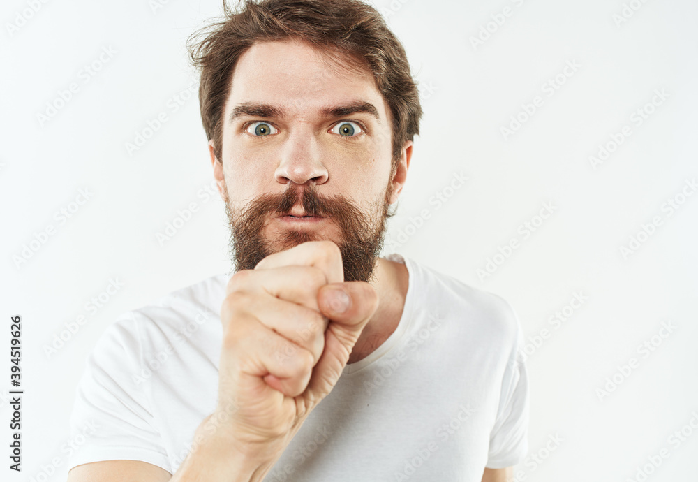 Emotional man on a white background in a T-shirt shows a gesture with his hands Emotional man on a white background in a T-shirt shows a gesture with his hands