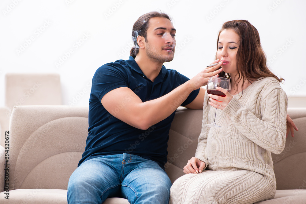 Man and pregnant woman in harmful habits concept Man and pregnant woman in harmful habits concept