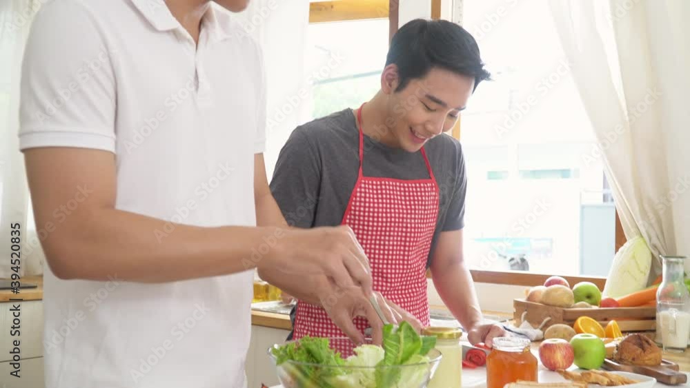 4K Happy Asian gay man couple cooking breakfast meal together in the kitchen. Smiling handsome guy LGBTQ lover enjoy with romantic lifestyle at home. Same-sex marriage and LGBT relationship concept. 4K Happy Asian gay man couple cooking breakfast meal together in the kitchen. Smiling handsome guy LGBTQ lover enjoy with romantic lifestyle at home. Same-sex marriage and LGBT relationship concept.