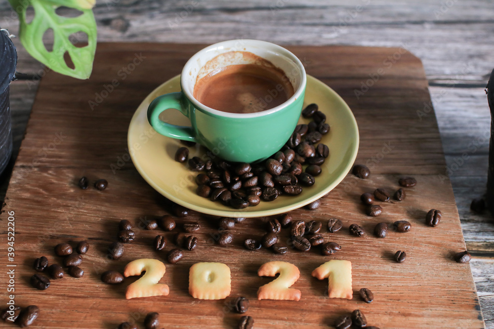 2021 bread number and coffee cup on wooden table with coffee beans.Happy new year 2021, Holidays food art concept. (close up) 2021 bread number and coffee cup on wooden table with coffee beans.Happy new year 2021, Holidays food art concept. (close up)