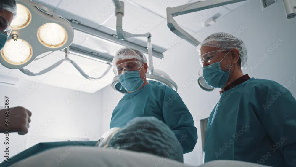 Collaborative cheerful medical team of doctors finishing operation successfully applauding celebrating with male patient in operating room. Healthcare. Collaborative cheerful medical team of doctors finishing operation successfully applauding celebrating with male patient in operating room. Healthcare.