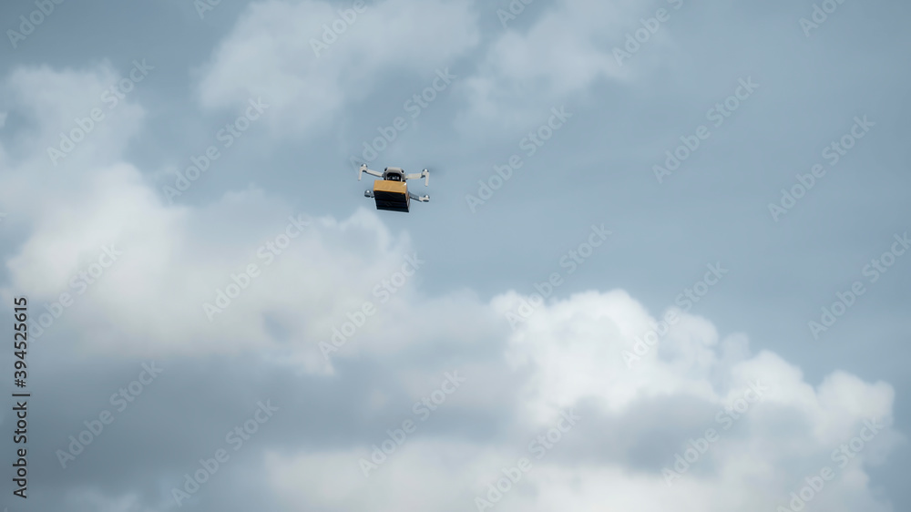 flying on a sky delivery drone with holding a .cardboard parcel flying on a sky delivery drone with holding a .cardboard parcel