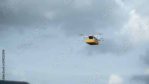 flying on a sky delivery drone with holding a .cardboard parcel
