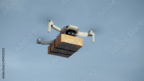 flying on a sky delivery drone with holding a .cardboard parcel photo