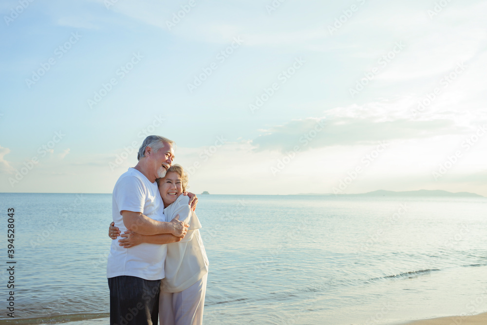 Asian couple senior elder retire resting embrace at sunset beach honeymoon Asian couple senior elder retire resting embrace at sunset beach honeymoon