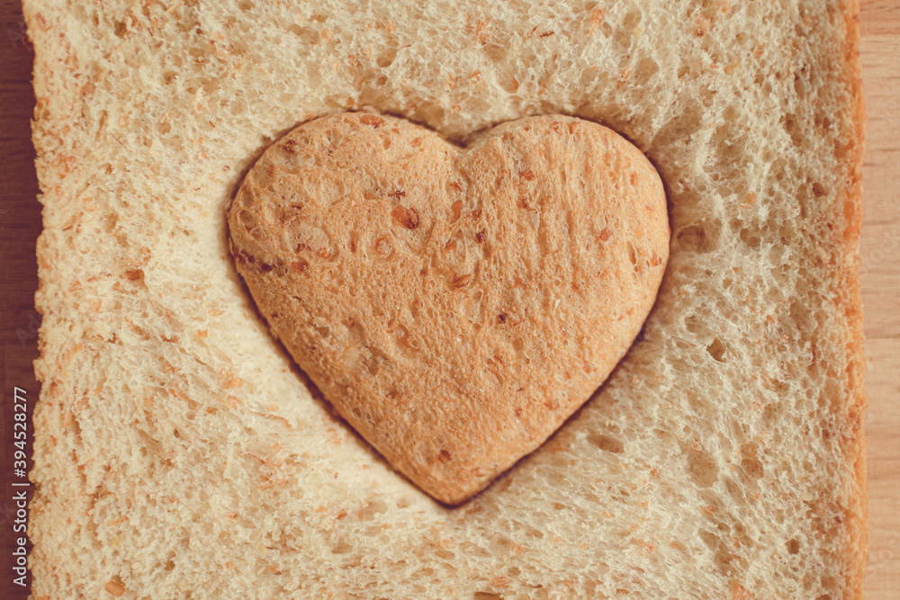 Obraz premium Grained bread cut off as heart shape. Concept of love and care in Valentine day.