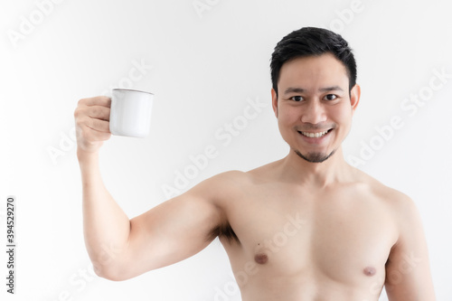 Topless healthy Asian man drinks the healthy coffee on isolated background.