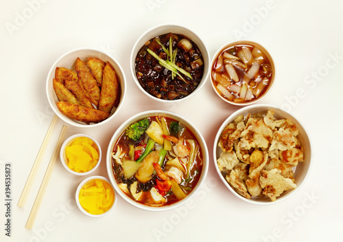 Chinese restaurant delivery food in paper container with wooden chopsticks. Isolated on white background. Top view. 