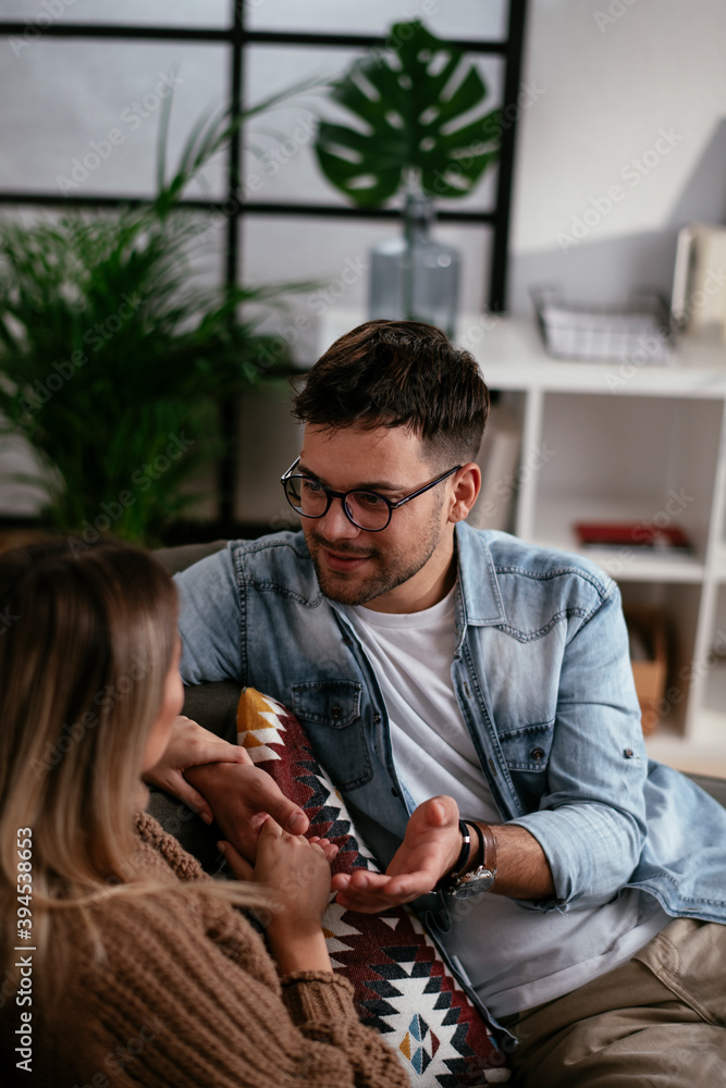 Young couple sitting and talking at home. Loving couple on a date. Young couple sitting and talking at home. Loving couple on a date.