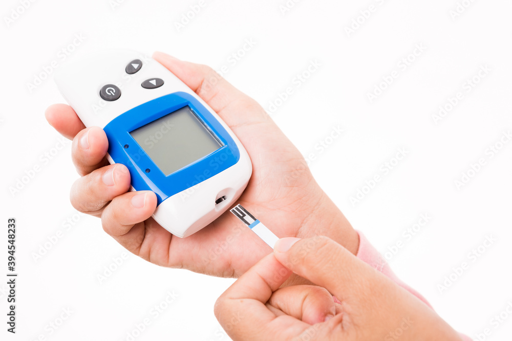 Closeup hands woman measuring glucose test level checking on a finger by glucometer she monitors and controls high blood sugar diabetes and glycemic health care concept isolated on white background Closeup hands woman measuring glucose test level checking on a finger by glucometer she monitors and controls high blood sugar diabetes and glycemic health care concept isolated on white background