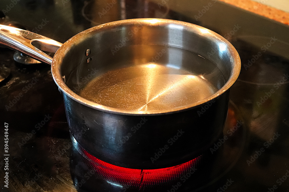 A pot of water simmering on a hot stove element A pot of water simmering on a hot stove element