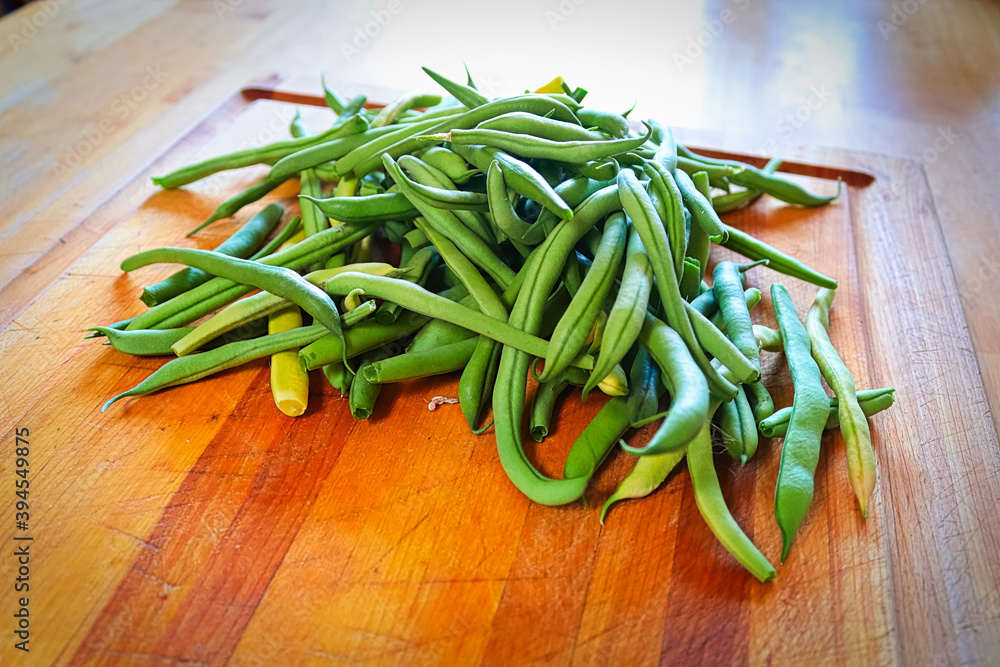 Fresh green beans in the middle of a cutting board Fresh green beans in the middle of a cutting board
