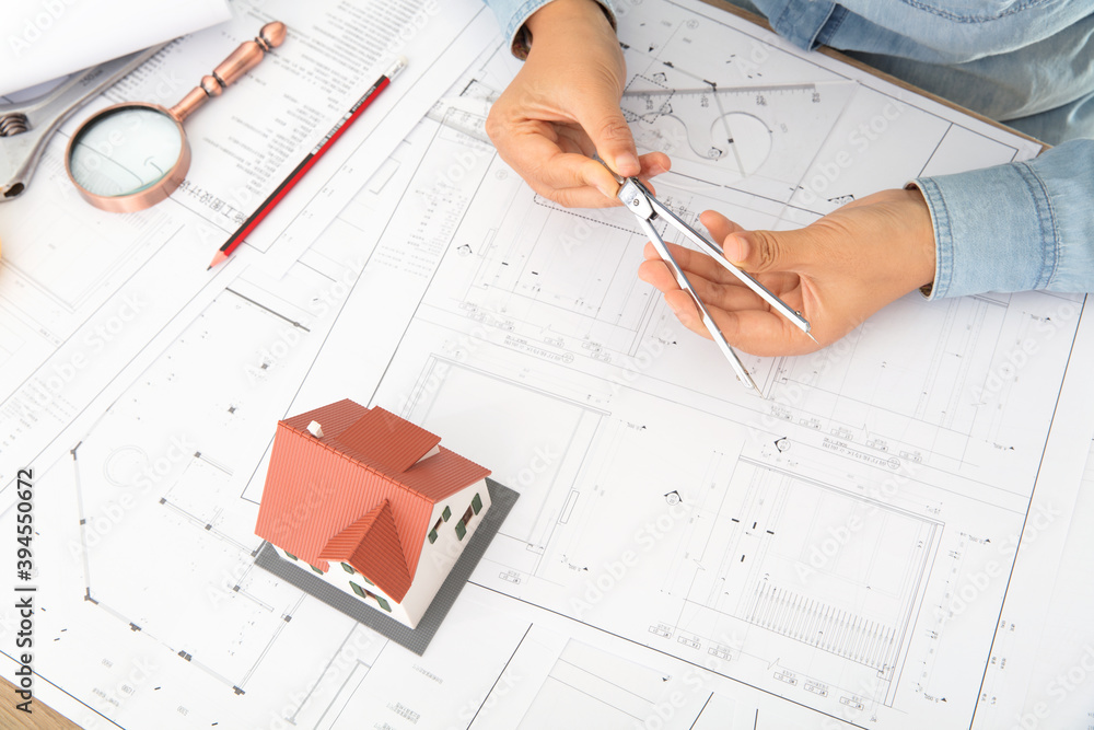 Looking down and shooting a table full of architectural drawings and designers at work